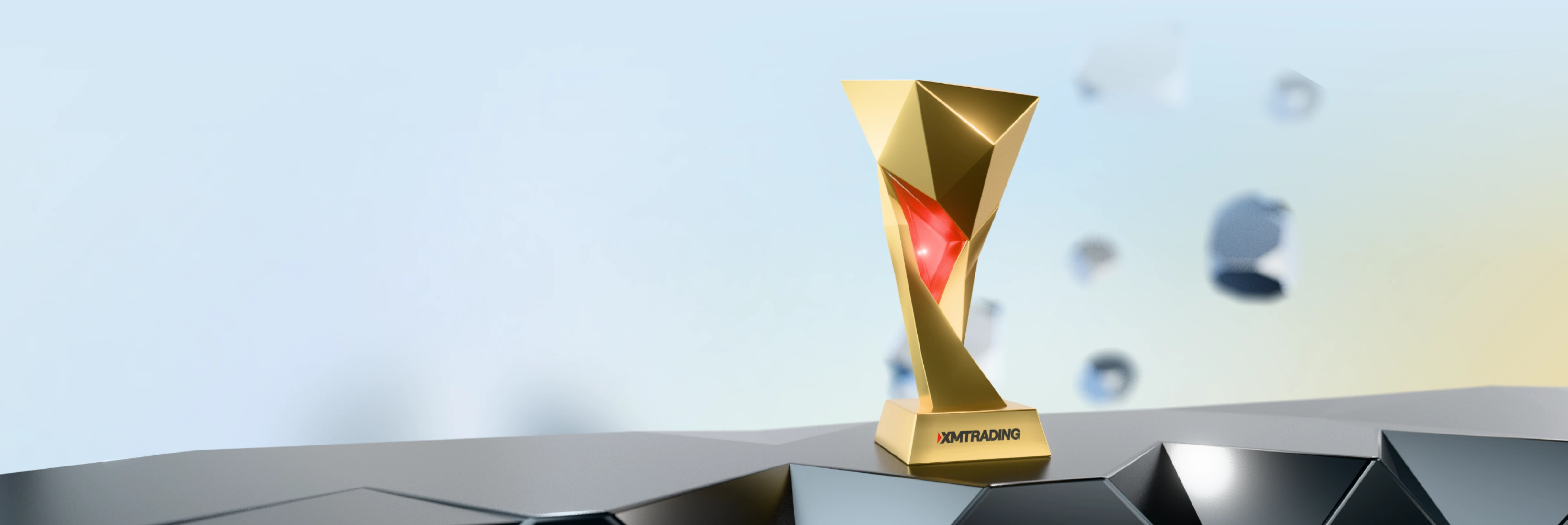 Golden geometric trophy with a red inner accent, standing on a base featuring the XMTrading logo.