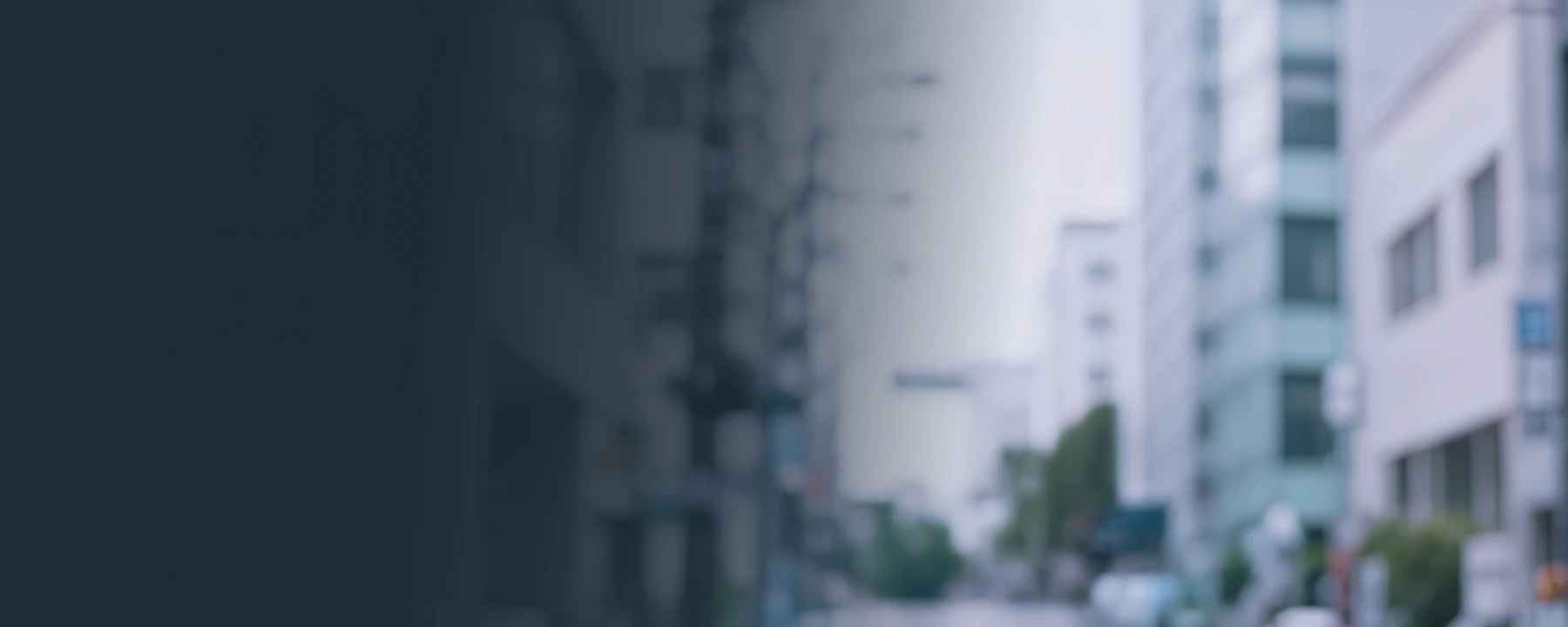 Smiling man looking at his smartphone outdoors, standing on a city street with a blurred urban background