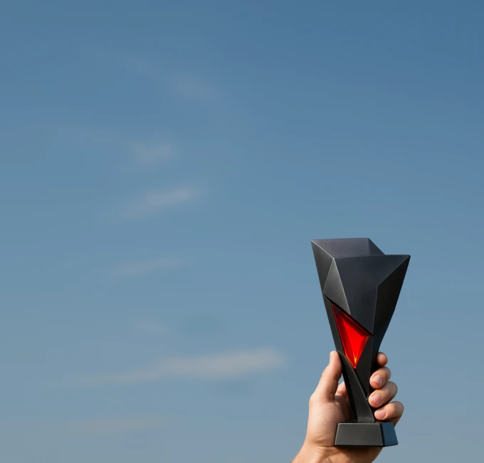 XMTrading affiliates league promotion illustrated with a hand holding a trophy against a clear sky