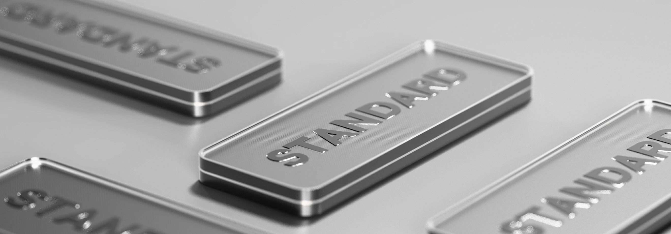 Close-up view of metallic nameplates displaying XMTrading account types, with a focus on the ‘Standard’ plate in a sleek silver finish
