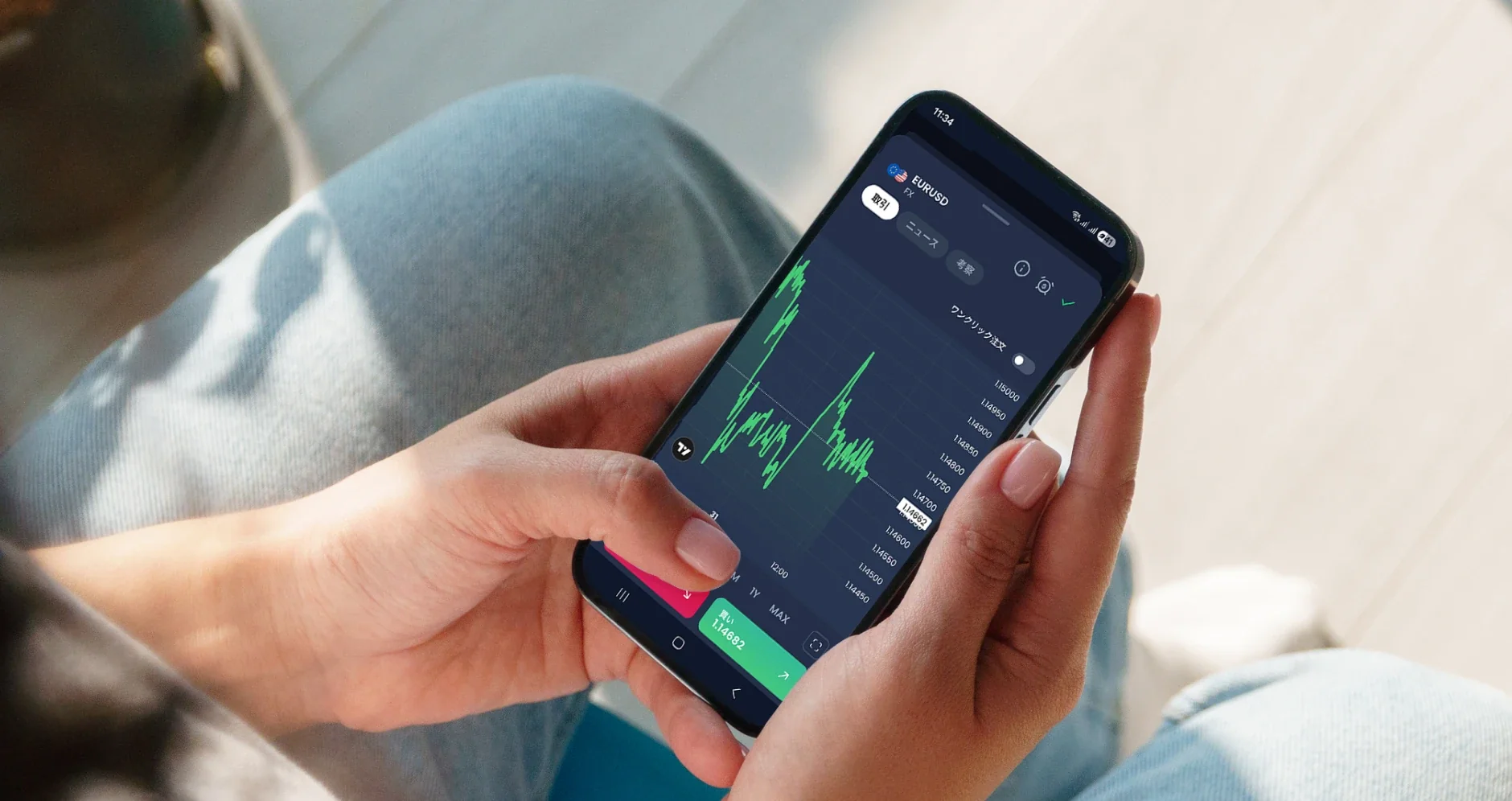 Person holding a smartphone displaying candlestick charts and market data for trading.