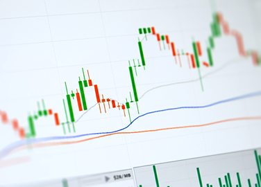 Financial charts with rising and falling candlestick graphs, highlighting XMTrading Chapter 3: Build a Winning Trading System