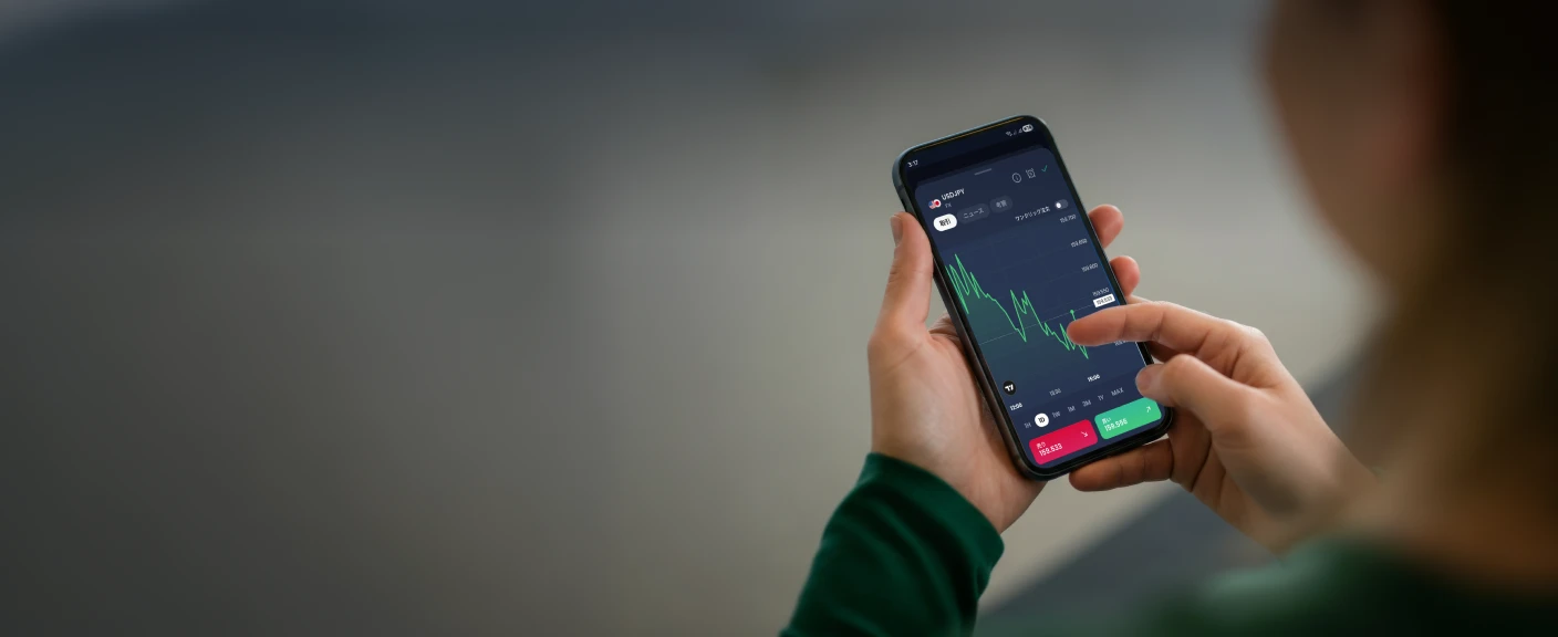 A person using a XMTD TraderPro displaying forex trading charts, symbolising growth and rewards through active trading.