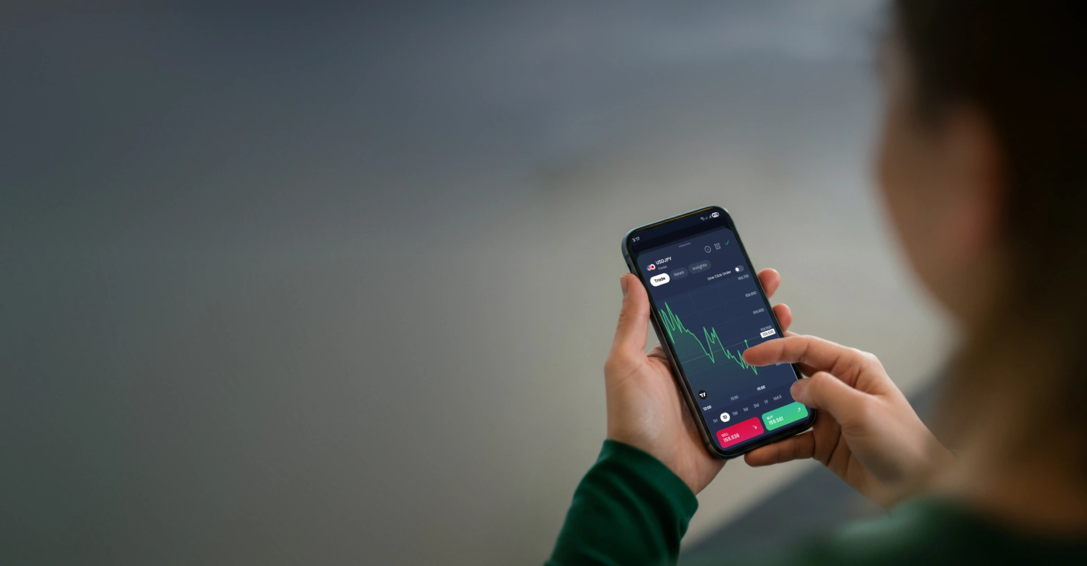 A person using a XMTD TraderPro displaying forex trading charts, symbolising growth and rewards through active trading.